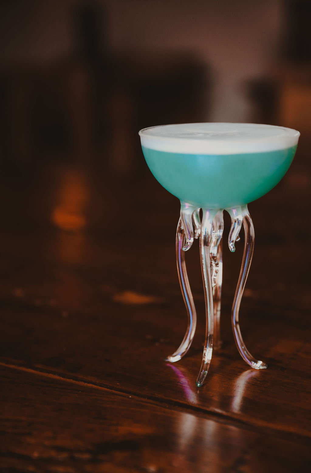 blue cocktail in an octopus shaped glass on a table
