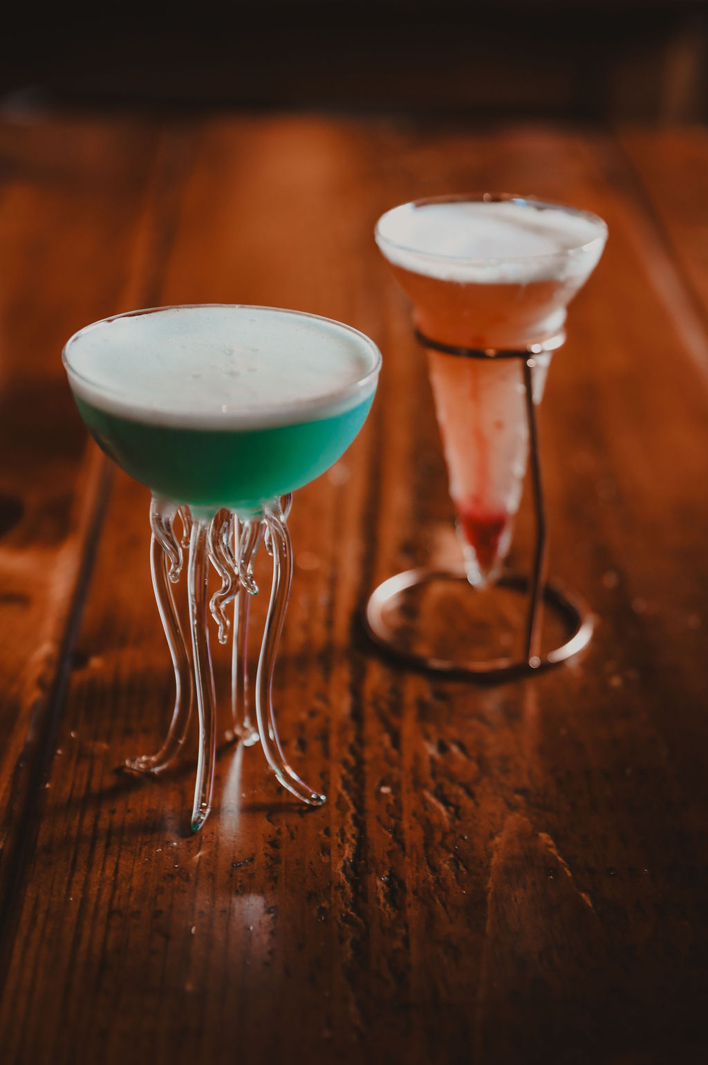 two cocktail glasses on a wooden table
