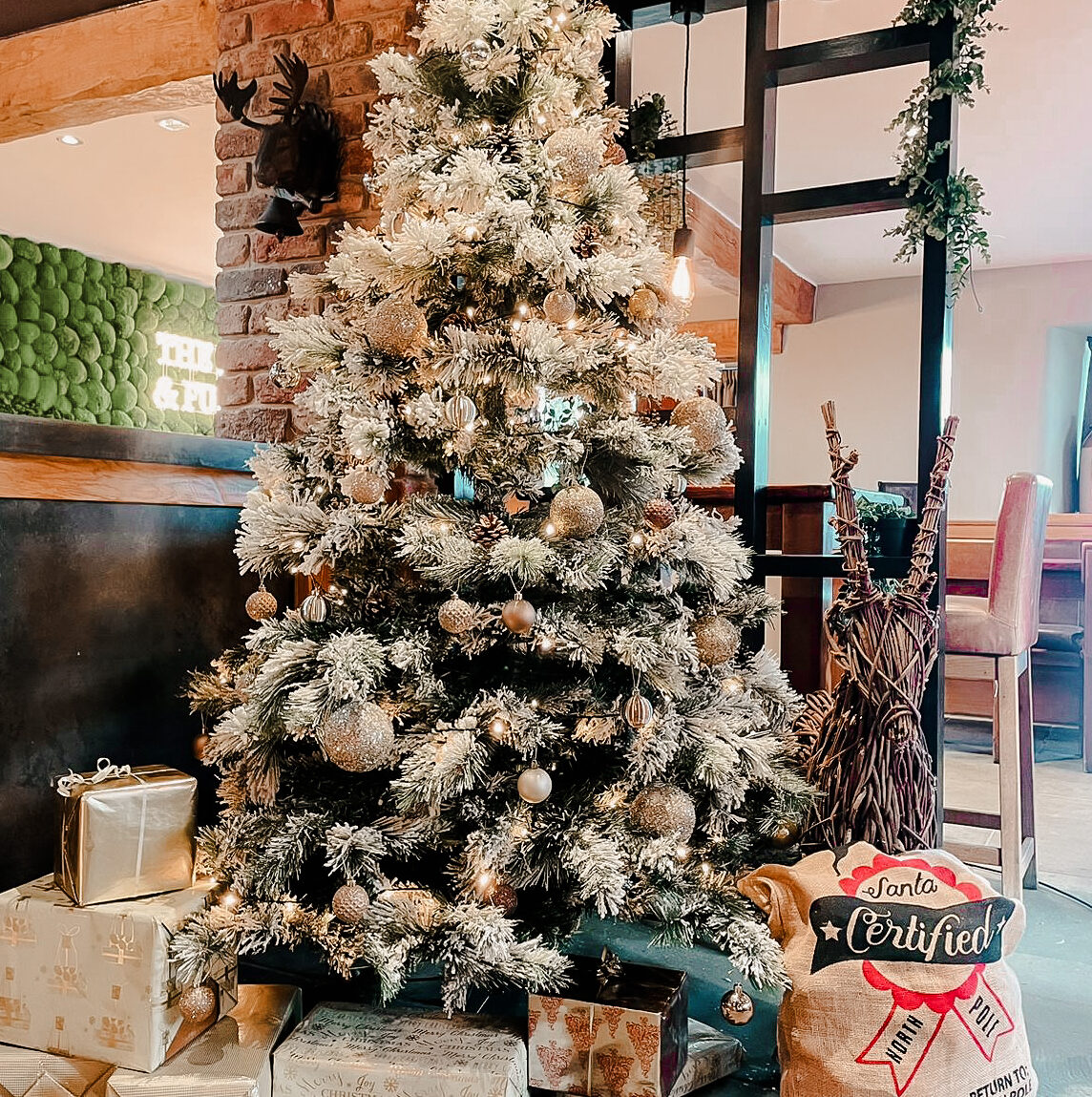 large snowy christmas tree with presents around the base